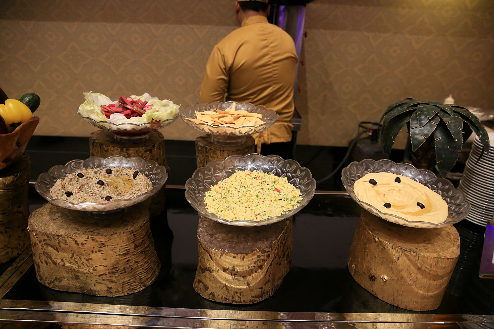 Dips and mezze in silver bowls on carved wooden stands