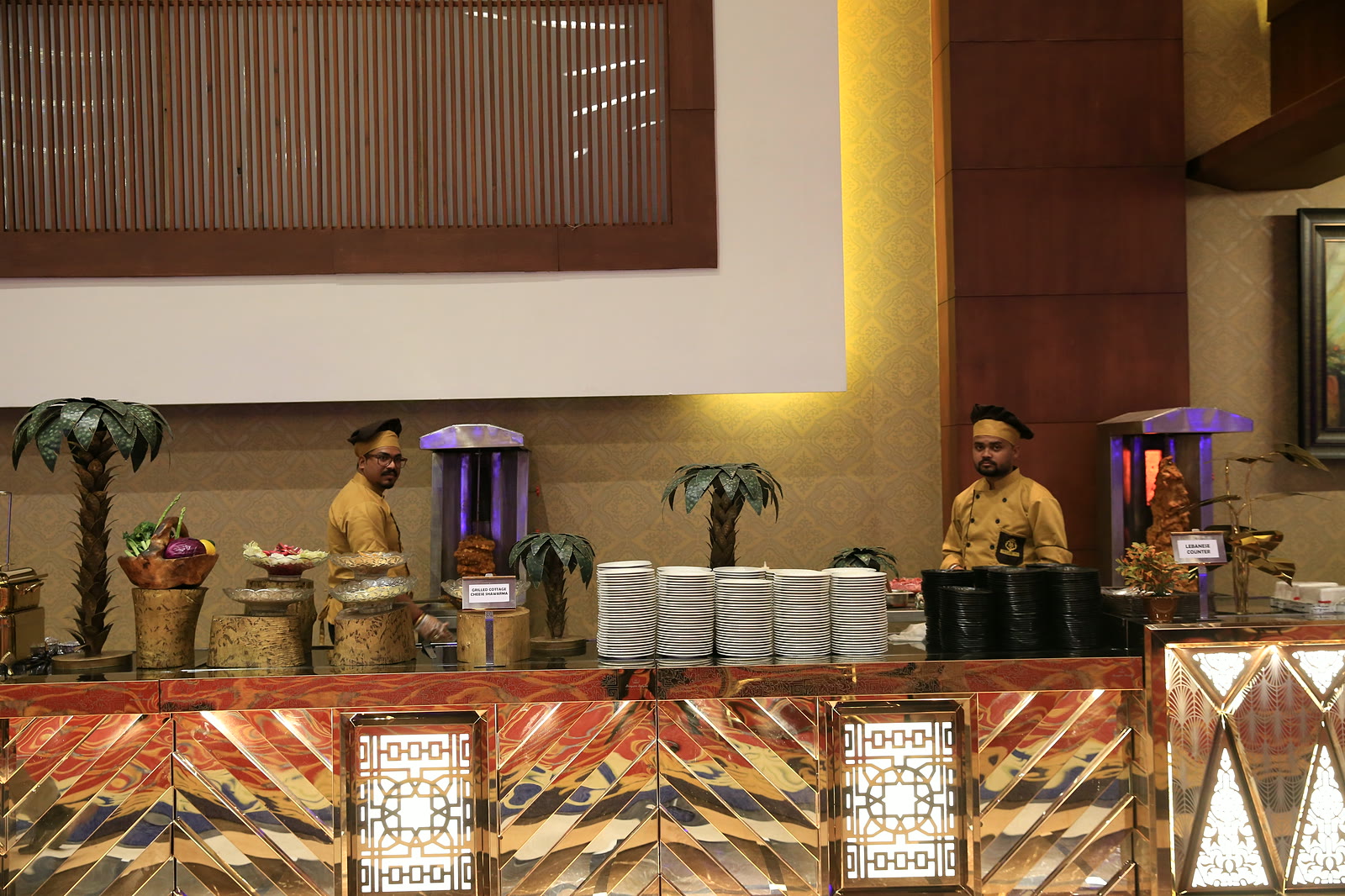 Live food counters along the hall, chefs in caps behind carved counter fronts