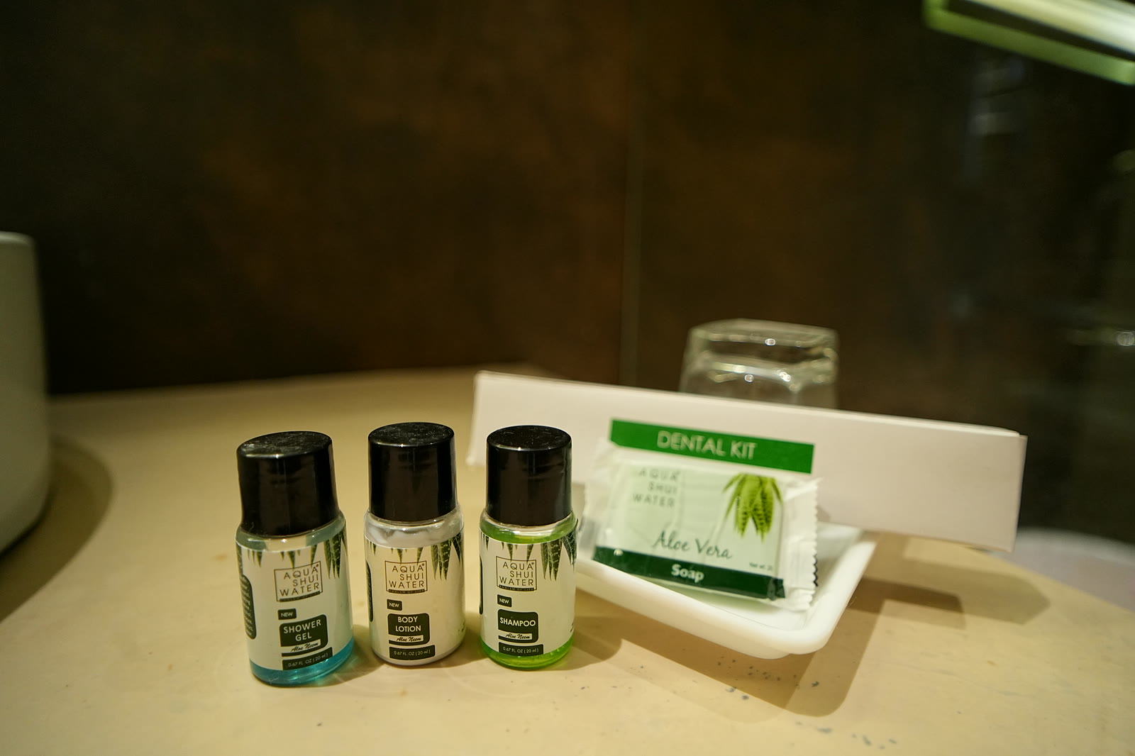 Shower gel, body lotion, shampoo, soap and a dental kit by the basin