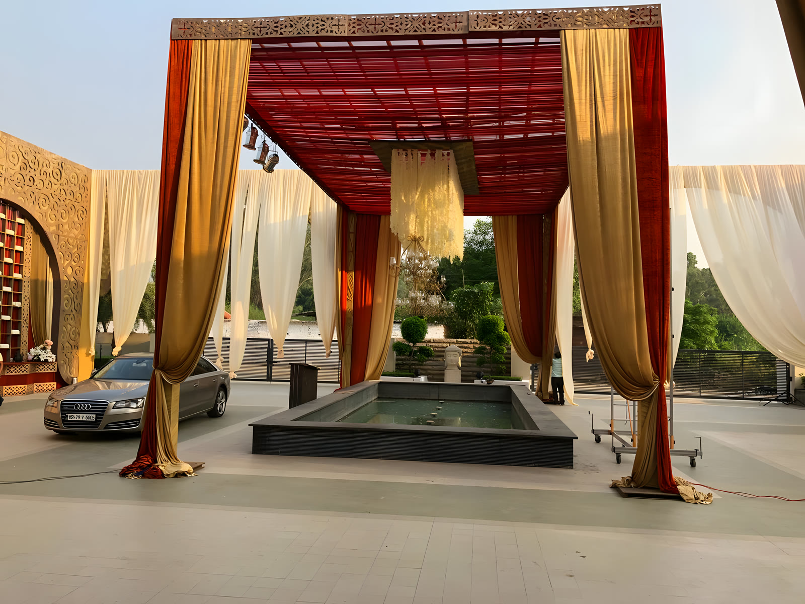 A draped red and gold canopy over the fountain pool at the entrance