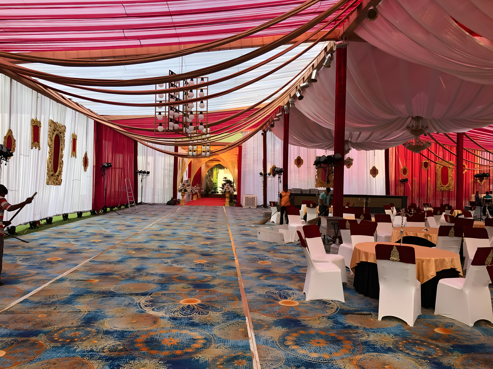 The hall draped in red and white, with dinner tables laid on a patterned carpet